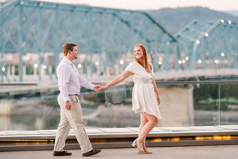 couple walking hand in hand, bridge in the background |©Sarah Larae Photography