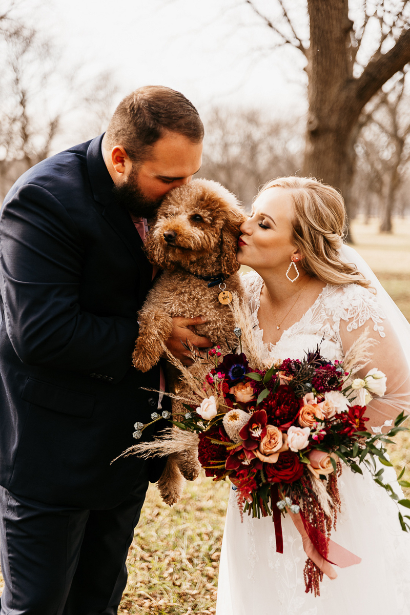 bride and groom kissing dog, fall dog-friendly wedding | ©Kelsey Marie Photography | Tulsa, OK