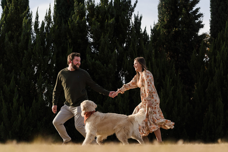 couple walking with English Cream Golden Retriever wearing rust bandana | ©Party of Two Photography