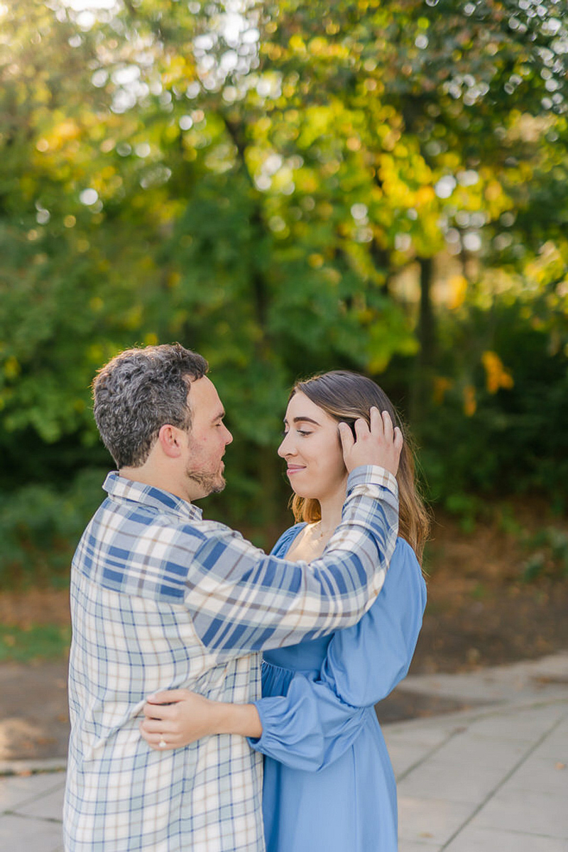 man brushing hair out of woman's face, romantic engagement photos | ©LaFountain Photography