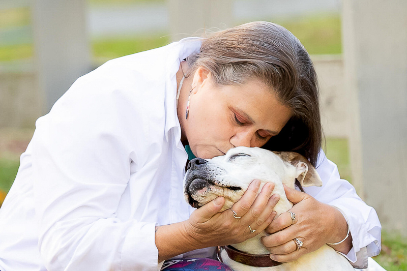 woman kissing the top of dog's head, end of life session | ©Emerald Moon Photography