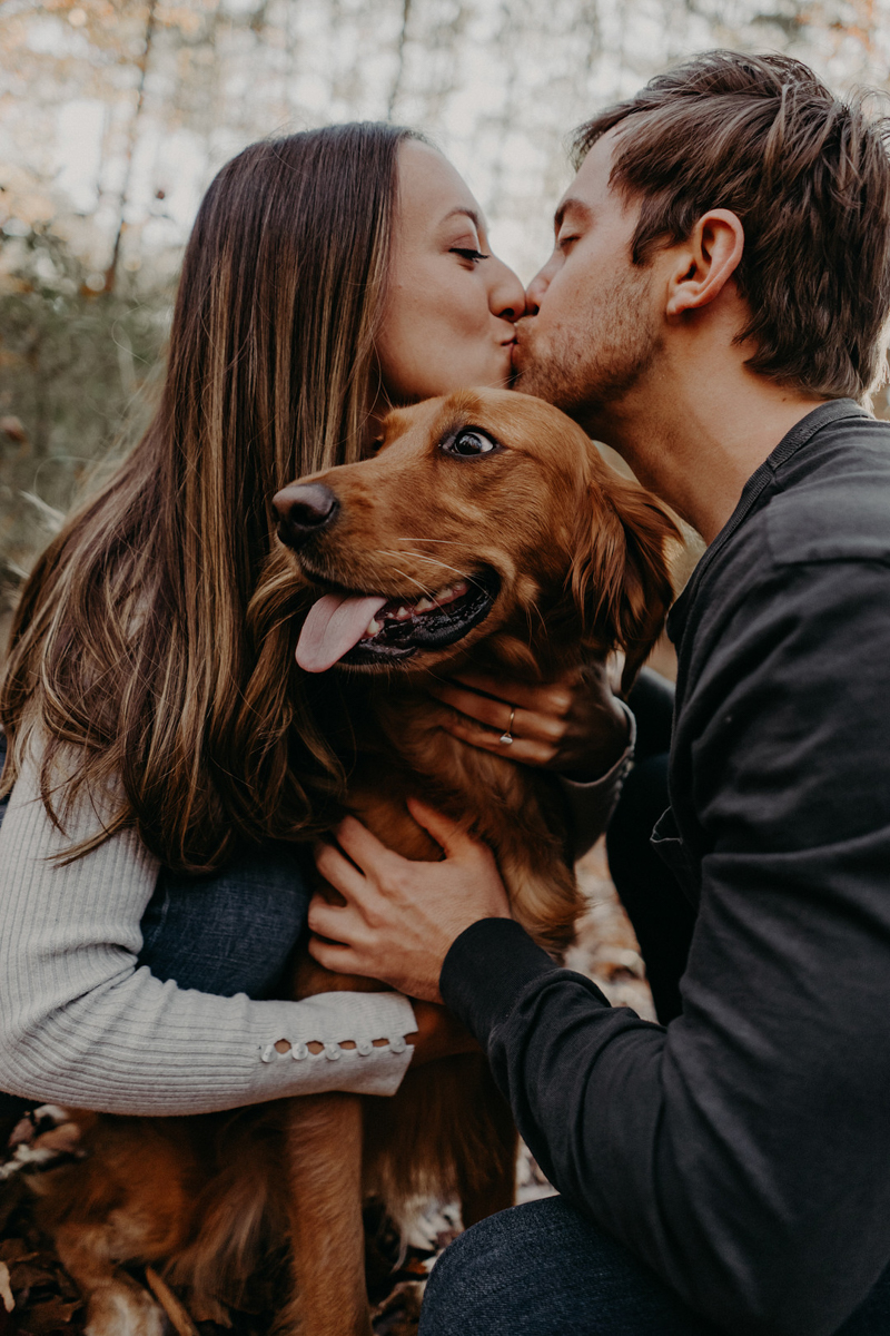 engaged couple kissing, dog sitting between them | Roswell, GA | winter engagement photos with a dog, ©Nathalia Frykman Photography