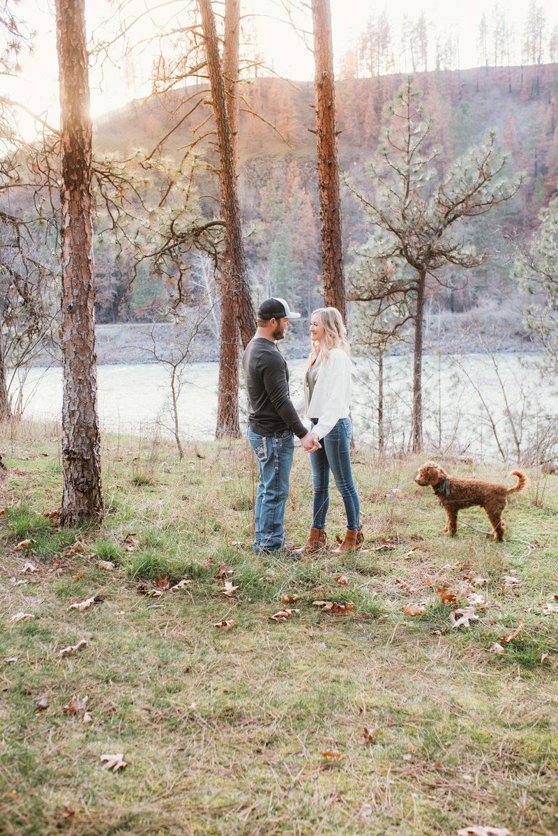 couple holding hands, dog nearby, outdoor engagement session | ©Courtney Kammers Photography