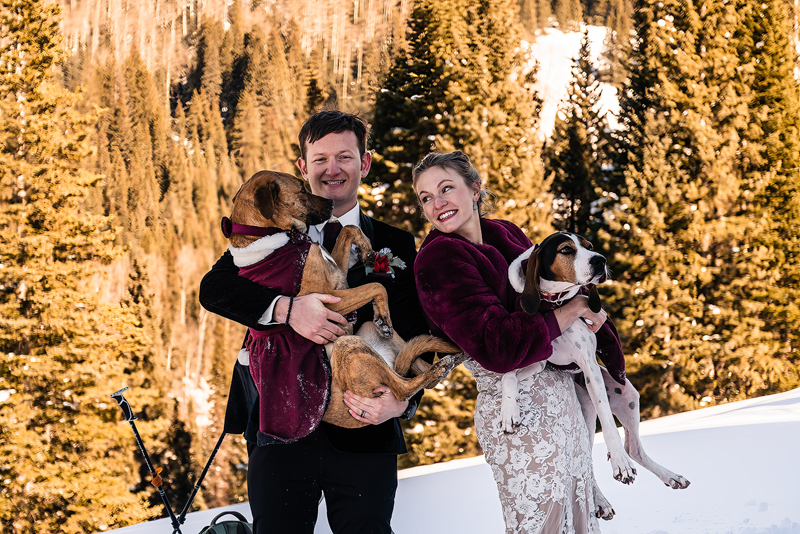 bride and groom holding their dogs, snowy elopement, ©The Outlovers | Adventure Elopement Photographers