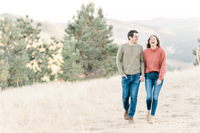 couple walking and holding hands, Mount Falcon engagement portraits | ©Mel Schroeder Photography, Denver based Wedding Photographer